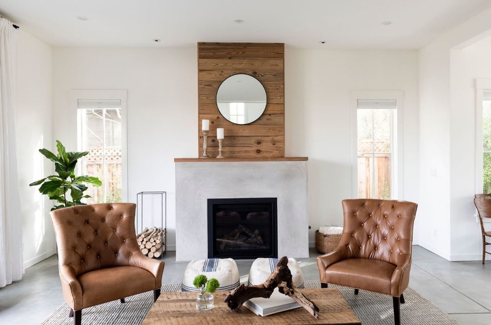Mittelgroßes, Offenes Landhausstil Wohnzimmer mit weißer Wandfarbe, Betonboden, Kaminumrandung aus Holz und grauem Boden in San Francisco