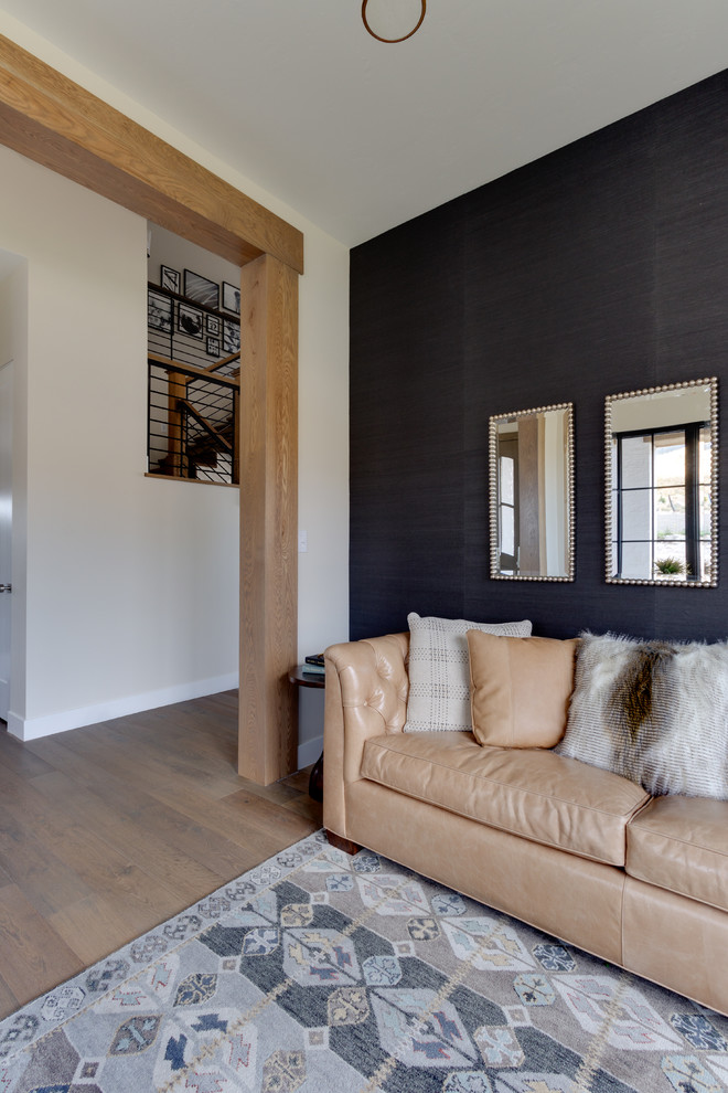 Diseño de salón de estilo de casa de campo de tamaño medio sin chimenea y televisor con paredes negras y suelo de madera clara