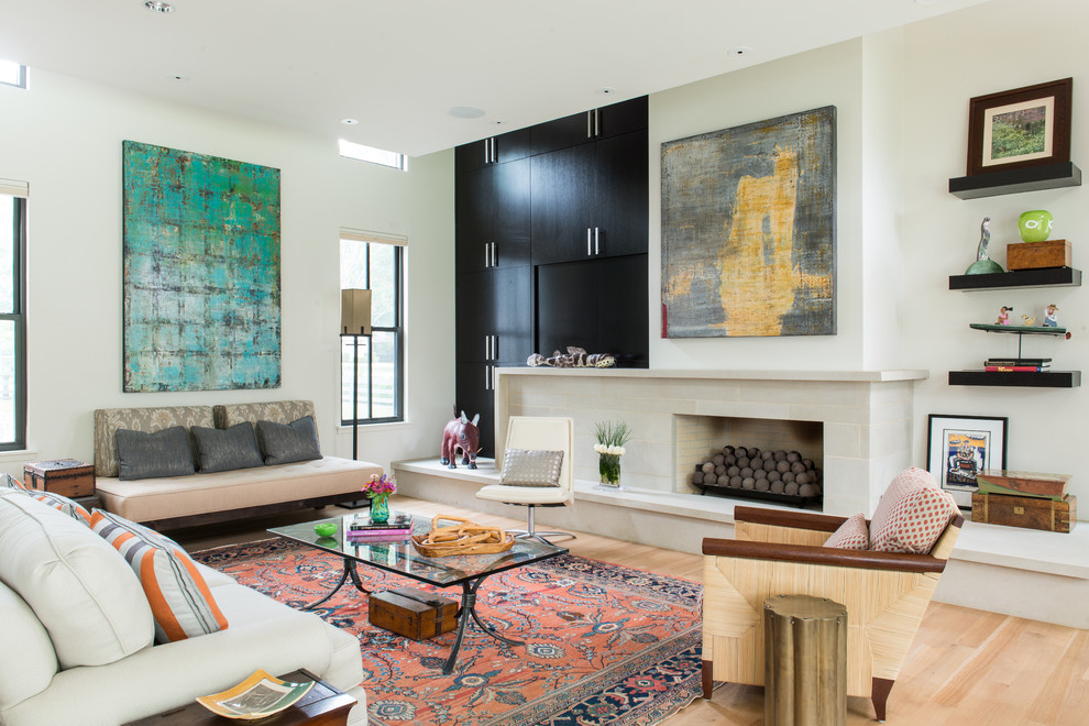 Mittelgroßes, Offenes Modernes Wohnzimmer mit weißer Wandfarbe, hellem Holzboden, Kamin, Kaminumrandung aus Stein und verstecktem TV in Dallas