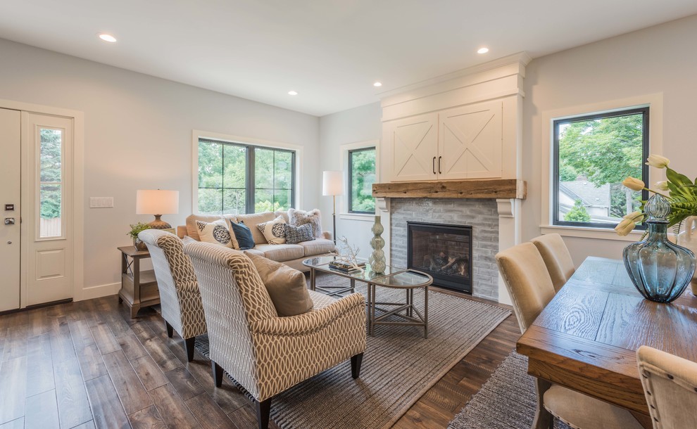Inspiration for a mid-sized farmhouse formal and open concept medium tone wood floor and brown floor living room remodel in Minneapolis with a standard fireplace, gray walls, a concealed tv and a tile fireplace