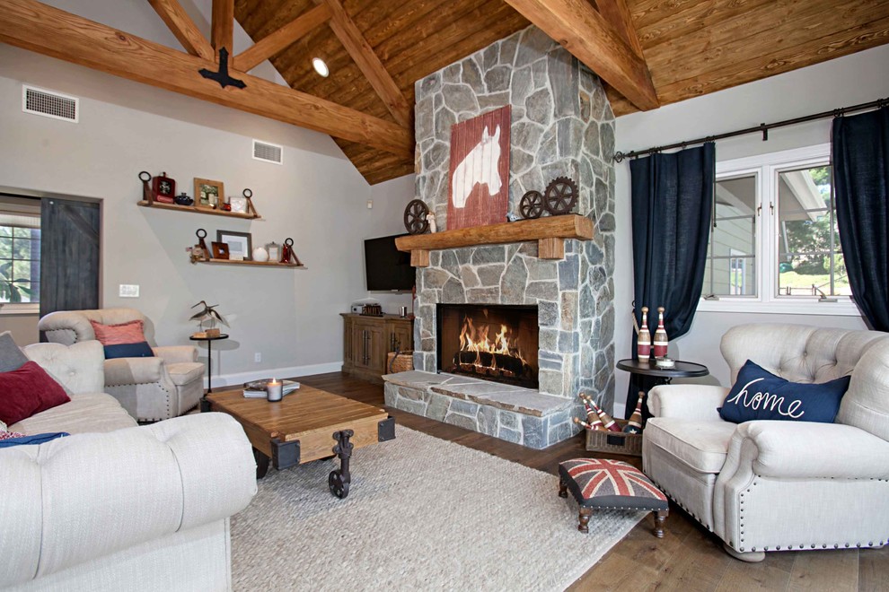 Country Wohnzimmer mit grauer Wandfarbe, dunklem Holzboden, Kamin und Kaminumrandung aus Stein in San Diego