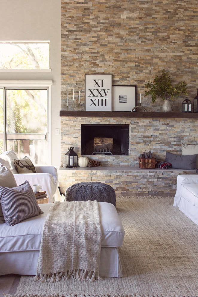 Inspiration pour un grand salon rustique ouvert avec un mur gris, parquet clair, une cheminée standard, un manteau de cheminée en pierre et un sol gris.