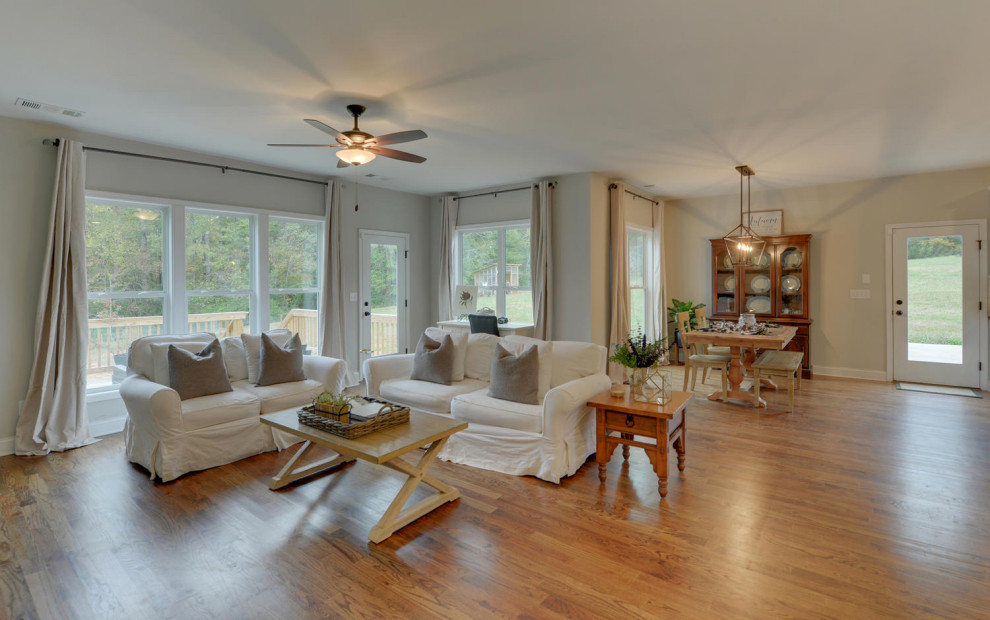 Immagine di un soggiorno country di medie dimensioni e aperto con pareti beige e pavimento in legno massello medio