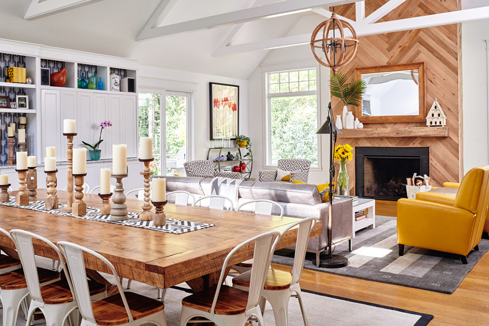 Exemple d'un très grand salon nature ouvert avec un mur blanc, un sol en bois brun, une cheminée standard, un manteau de cheminée en bois, un téléviseur dissimulé et un plafond voûté.