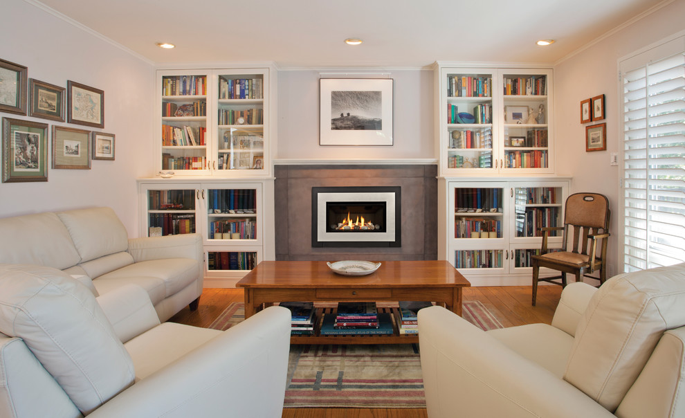 Photo of a medium sized classic formal enclosed living room in Portland with white walls, dark hardwood flooring, a standard fireplace, a concrete fireplace surround and no tv.