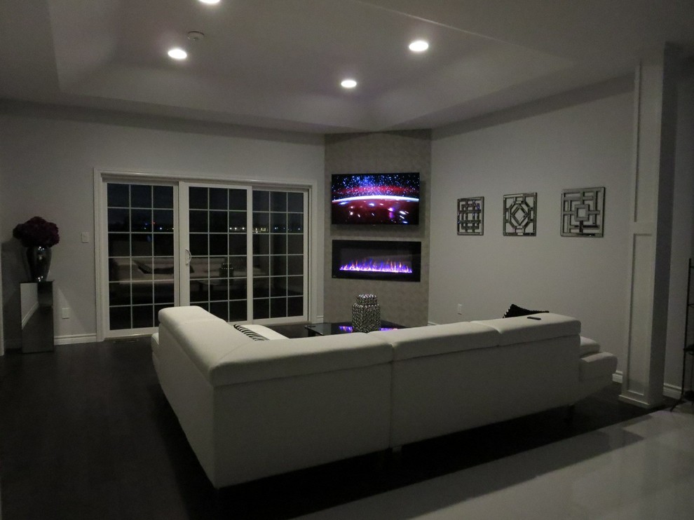 Idéer för mellanstora funkis separata vardagsrum, med grå väggar, mörkt trägolv, en bred öppen spis och en väggmonterad TV