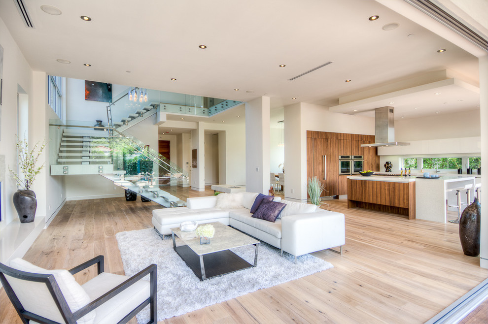 Großes, Offenes Modernes Wohnzimmer mit weißer Wandfarbe, hellem Holzboden, Hängekamin, gefliester Kaminumrandung und beigem Boden in Los Angeles