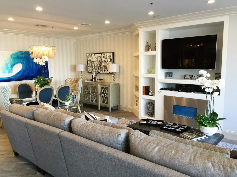 На фото: открытая гостиная комната среднего размера в стиле модернизм с серыми стенами, полом из керамогранита, стандартным камином, мультимедийным центром, фасадом камина из металла и коричневым полом с