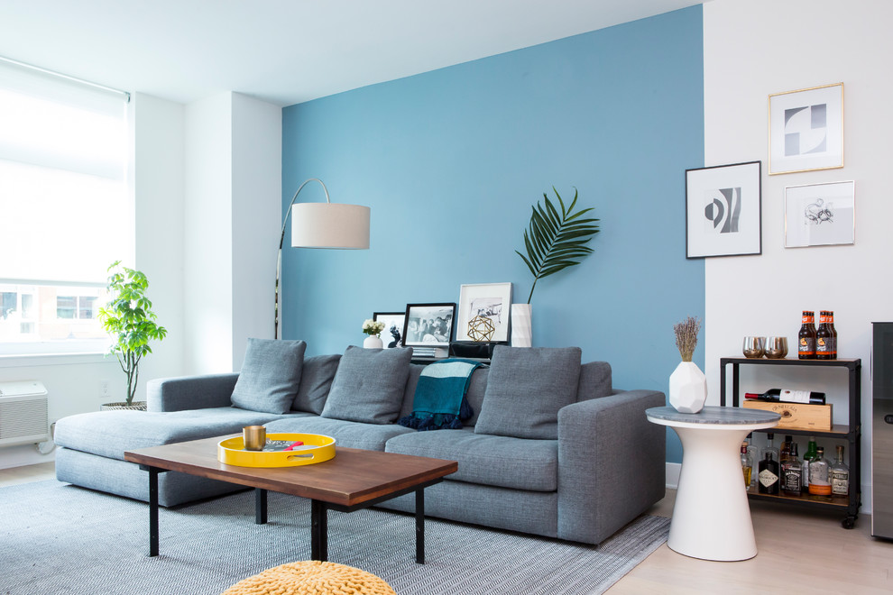 Idée de décoration pour un salon design avec un bar de salon, un mur bleu et un sol beige.