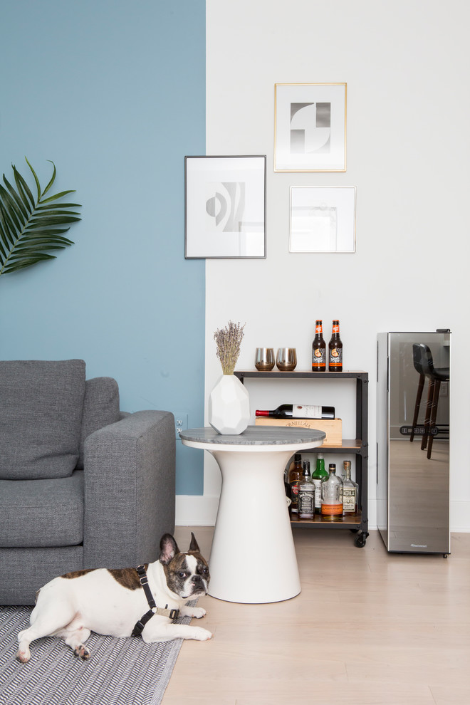 Diseño de salón con barra de bar abierto tradicional renovado de tamaño medio con paredes azules, suelo de madera clara, televisor independiente y suelo blanco