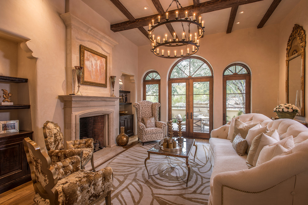 This is an example of a large mediterranean formal enclosed living room in Phoenix with beige walls, medium hardwood flooring, a standard fireplace, no tv and a stone fireplace surround.