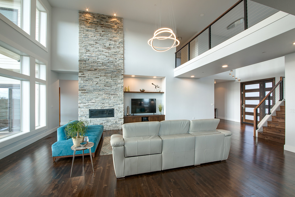 Пример оригинального дизайна: открытая гостиная комната среднего размера в стиле модернизм с белыми стенами, темным паркетным полом, горизонтальным камином, фасадом камина из камня, отдельно стоящим телевизором и коричневым полом