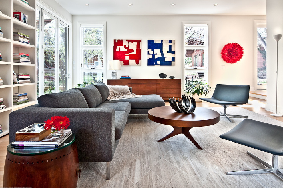 This is an example of a large contemporary open plan living room in Los Angeles with white walls and light hardwood flooring.