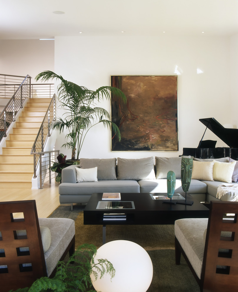 Exemple d'un grand salon moderne ouvert avec une salle de musique, un mur beige, parquet clair, une cheminée standard, un manteau de cheminée en béton, aucun téléviseur et un sol beige.