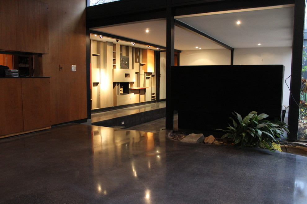Exemple d'un salon moderne ouvert avec sol en béton ciré.