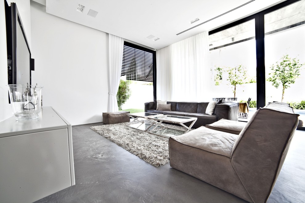 Inspiration for a large contemporary concrete floor living room remodel with white walls, no fireplace and a wall-mounted tv