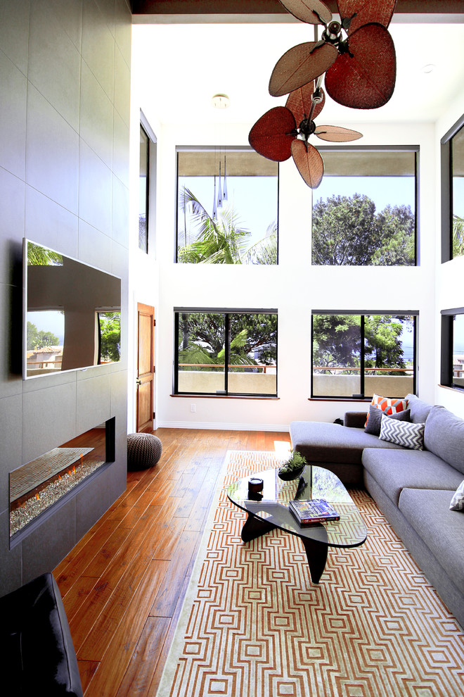 Modernes Wohnzimmer im Loft-Stil mit weißer Wandfarbe, braunem Holzboden, Gaskamin und gefliester Kaminumrandung in San Diego
