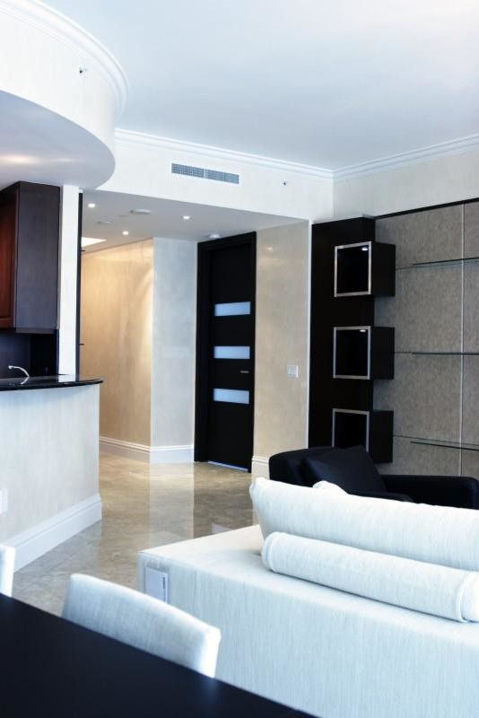 Ispirazione per un soggiorno design di medie dimensioni e aperto con pareti beige, pavimento in marmo, parete attrezzata e pavimento grigio