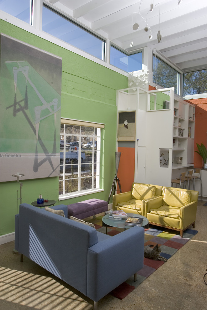 Modern inredning av ett vardagsrum, med betonggolv och gröna väggar