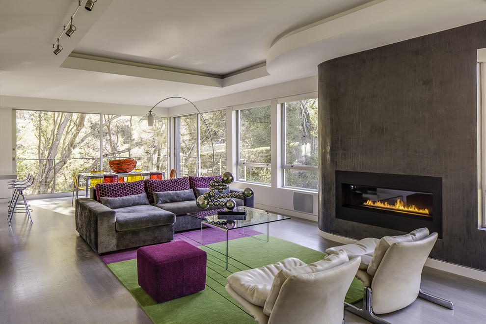 This is an example of a contemporary open plan living room in San Francisco with a ribbon fireplace and grey floors.