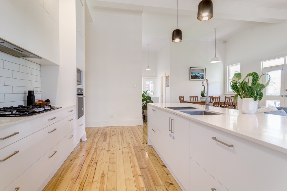 Immagine di una cucina design di medie dimensioni con parquet chiaro