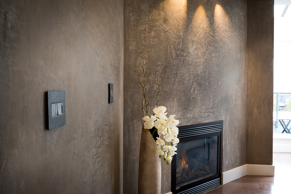 Réalisation d'un petit salon design ouvert avec un mur marron, parquet foncé, une cheminée standard et un manteau de cheminée en plâtre.