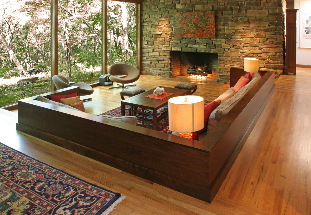 Idee per un grande soggiorno contemporaneo aperto con pavimento in legno massello medio, camino classico, cornice del camino in pietra e tappeto