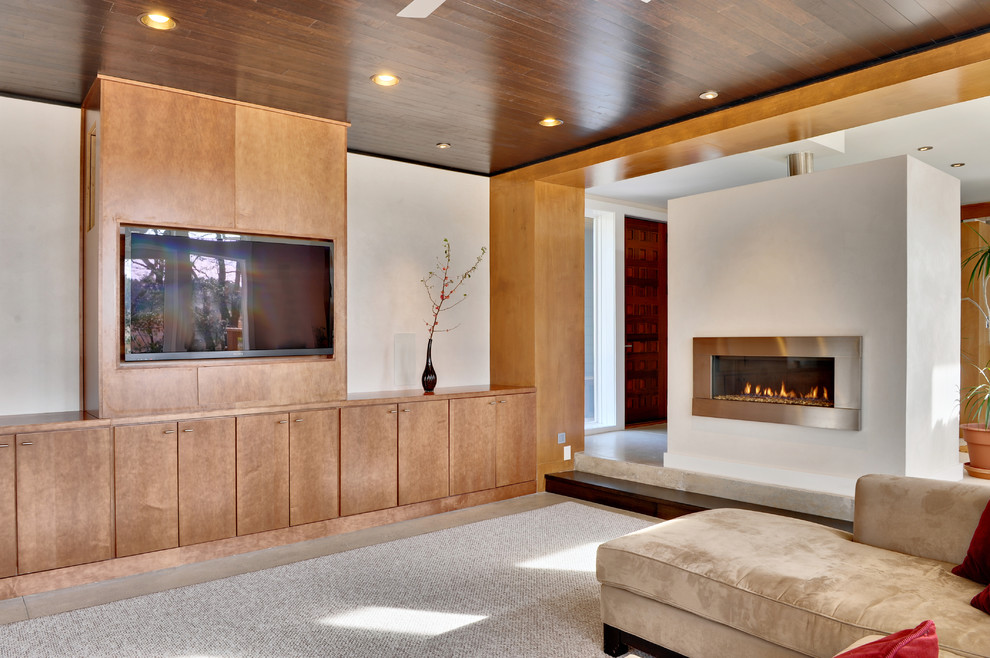 Idée de décoration pour un salon design avec une cheminée ribbon et un téléviseur encastré.