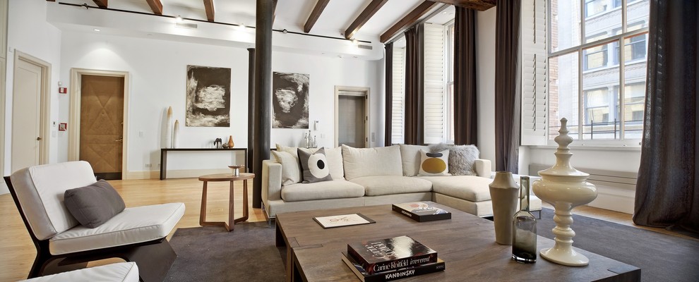 Imagen de salón minimalista con paredes blancas, suelo de madera clara y alfombra