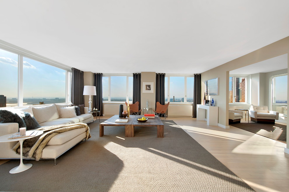 Example of a huge minimalist living room design in New York with beige walls