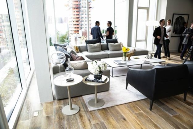 Cette image montre un salon minimaliste ouvert avec une salle de réception, un mur blanc et un sol en bois brun.