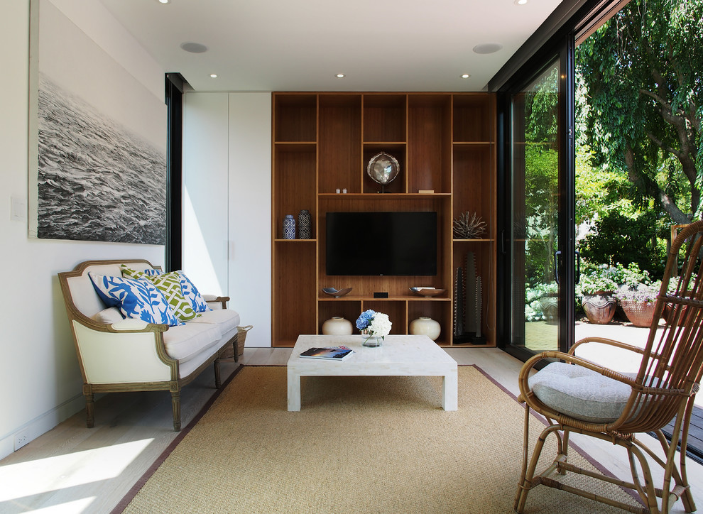 Immagine di un piccolo soggiorno moderno chiuso con pareti bianche, parquet chiaro e TV a parete