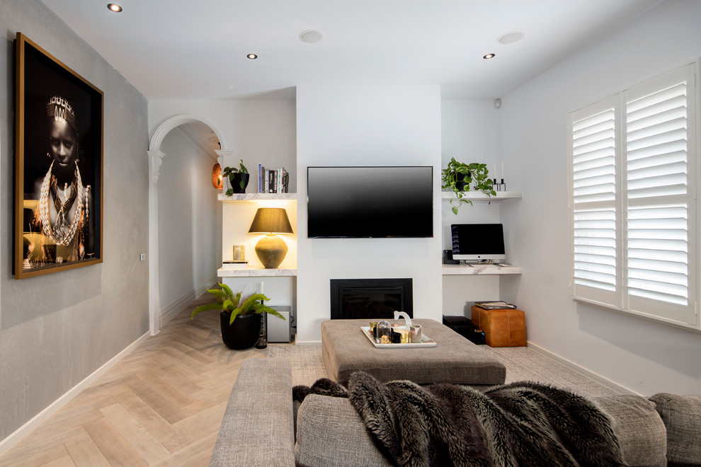 Esempio di un soggiorno minimal aperto e di medie dimensioni con pareti bianche, parquet chiaro, camino classico, cornice del camino in intonaco e TV a parete