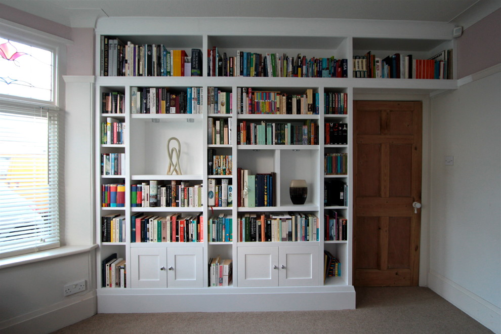 Idee per un grande soggiorno minimalista chiuso con libreria, pareti bianche e moquette