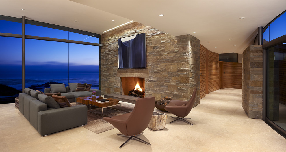 Cette image montre un salon design avec une cheminée standard, un manteau de cheminée en pierre et un téléviseur fixé au mur.