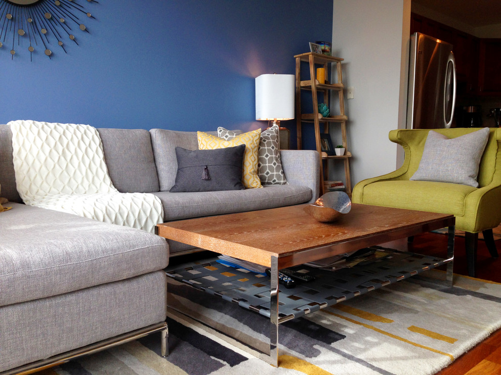 Idée de décoration pour un petit salon minimaliste ouvert avec un mur bleu, un sol en bois brun et un sol gris.