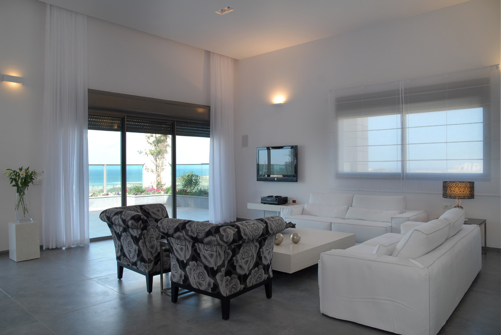 Immagine di un soggiorno minimalista con pareti bianche e pavimento in cemento