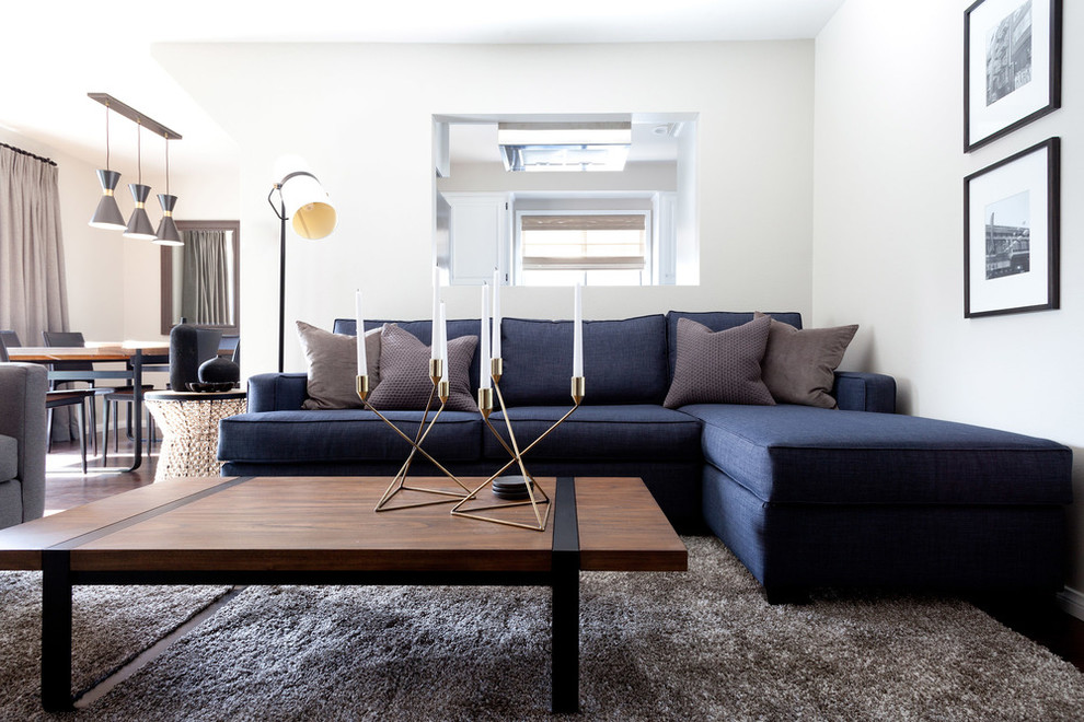 Modern open plan living room in Orange County with white walls and dark hardwood flooring.
