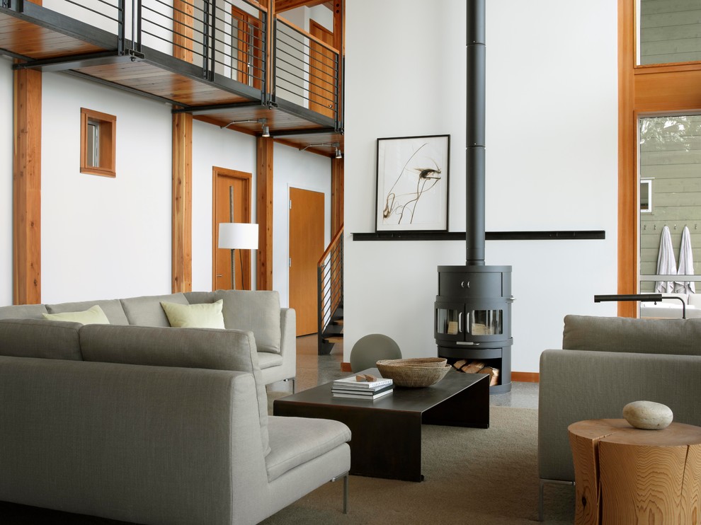 This is an example of a modern living room in San Francisco with white walls, no tv and a wood burning stove.