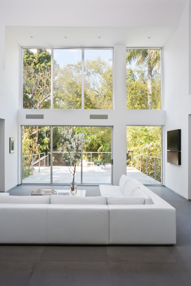 Esempio di un soggiorno minimalista stile loft con sala formale, pareti bianche e pavimento in pietra calcarea