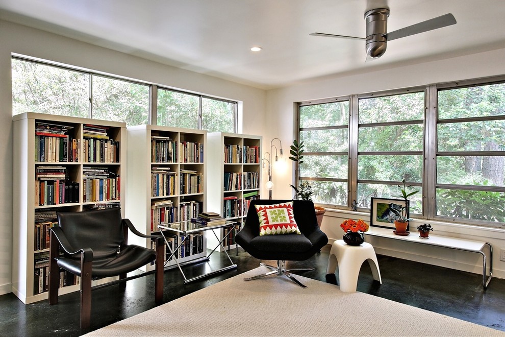 На фото: гостиная комната в стиле модернизм с с книжными шкафами и полками с