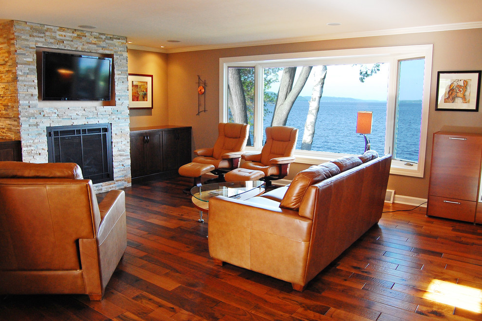 Example of a trendy open concept dark wood floor living room design in Other with beige walls, a standard fireplace, a stone fireplace and a media wall
