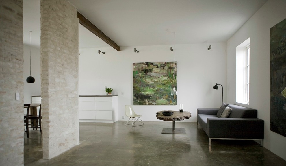 Idée de décoration pour un salon minimaliste avec sol en béton ciré, un mur blanc et un mur en pierre.