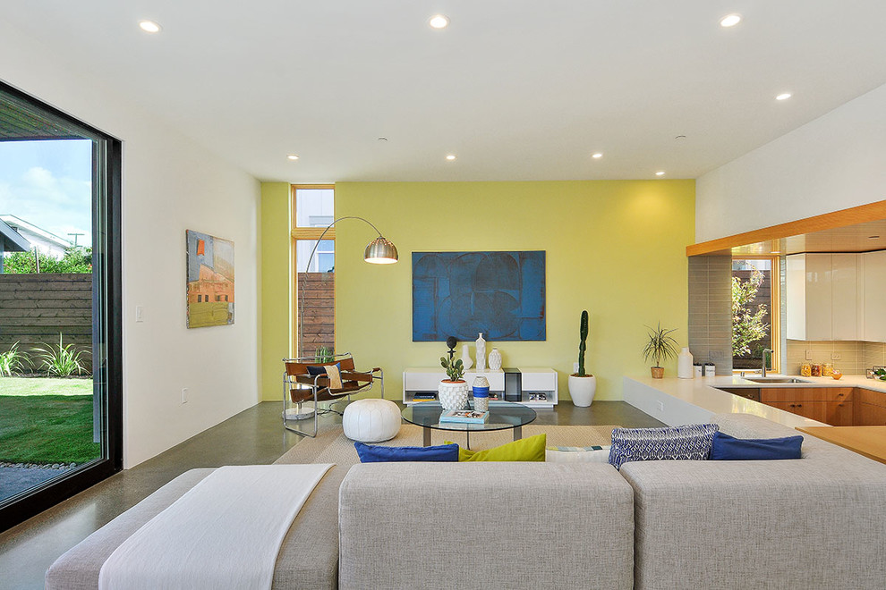 Large contemporary open plan living room in San Francisco with green walls, concrete flooring and no fireplace.