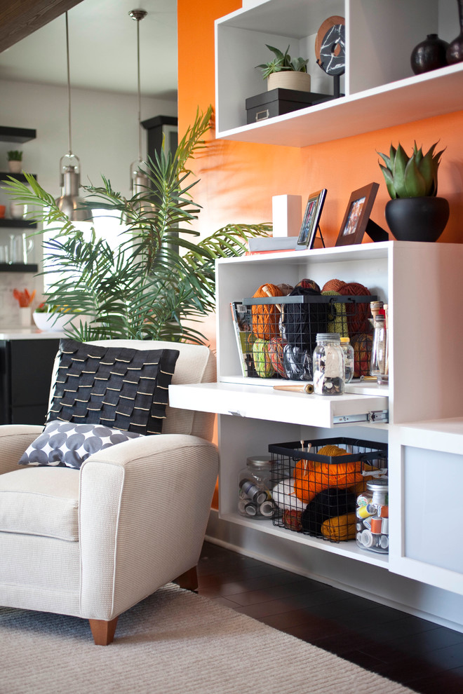 Стильный дизайн: открытая гостиная комната среднего размера в стиле модернизм с оранжевыми стенами, темным паркетным полом, стандартным камином, фасадом камина из плитки и отдельно стоящим телевизором - последний тренд