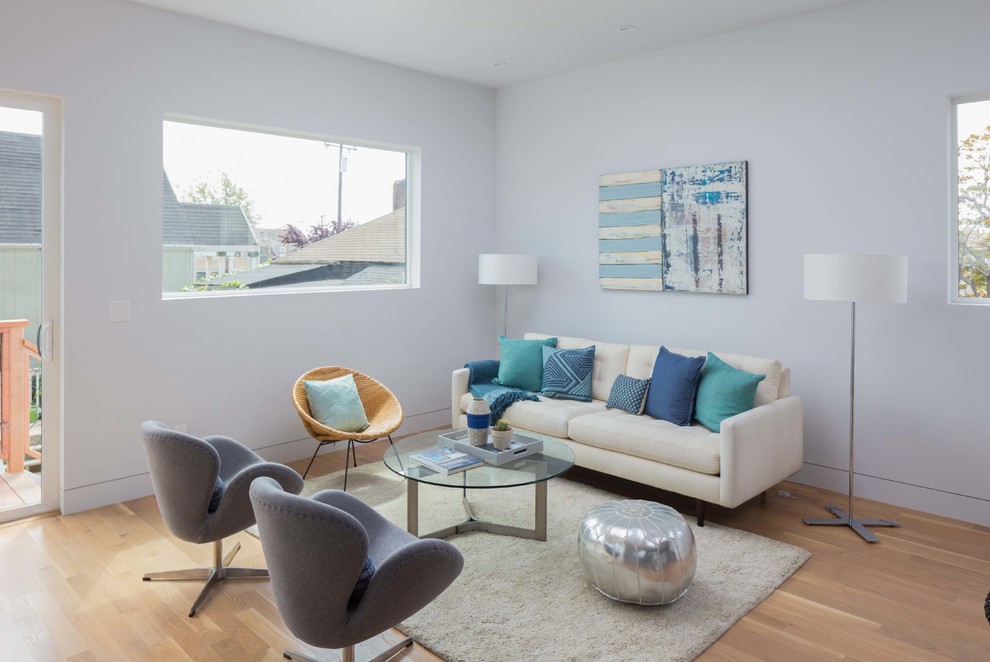 Esempio di un soggiorno minimalista di medie dimensioni e aperto con pareti bianche, pavimento in legno massello medio, nessun camino e TV autoportante