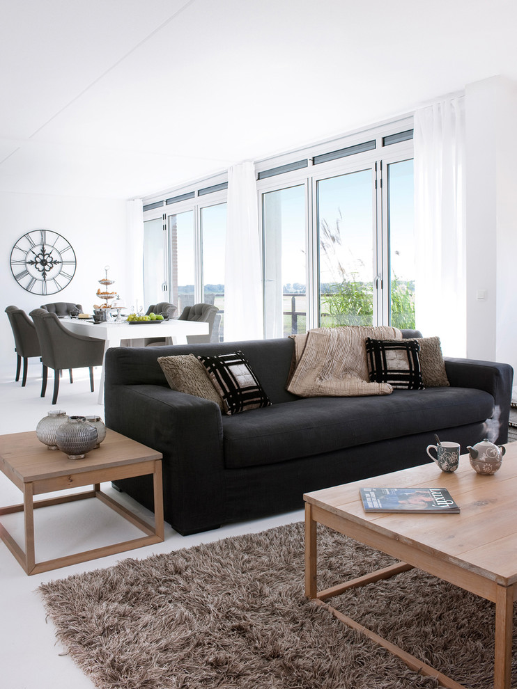 Стильный дизайн: открытая гостиная комната в стиле модернизм с белыми стенами и ковром на полу - последний тренд