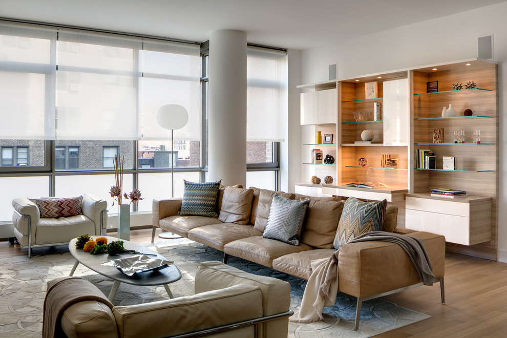 На фото: открытая гостиная комната в стиле модернизм с белыми стенами, светлым паркетным полом, коричневым полом и коричневым диваном