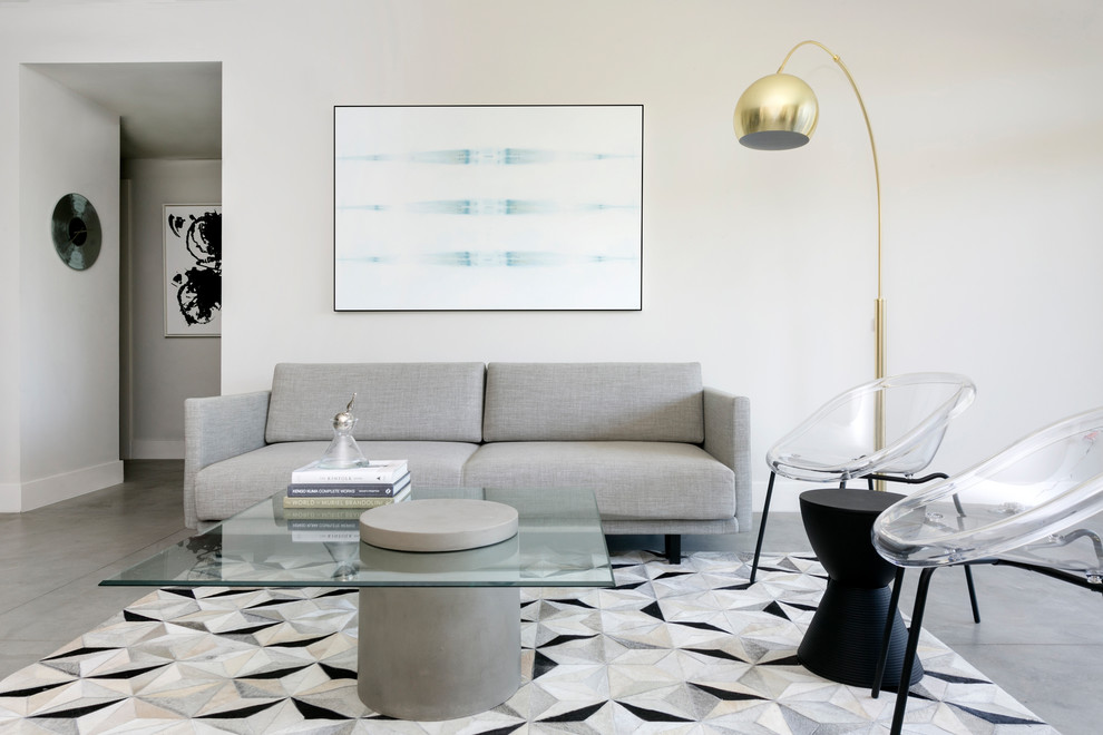 Immagine di un piccolo soggiorno minimalista stile loft con pareti grigie, pavimento in cemento, nessun camino, TV a parete e pavimento grigio
