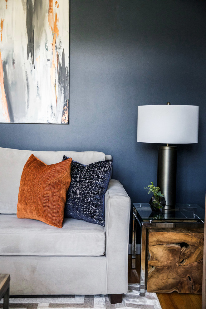 Idee per un piccolo soggiorno minimalista chiuso con pareti blu, pavimento in legno massello medio, nessun camino, TV a parete e pavimento grigio